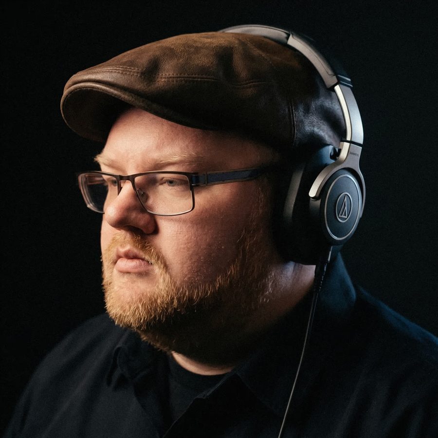 Portrait of D.L. Watson, founder and senior editor of Cutpoint Studio, wearing headphones